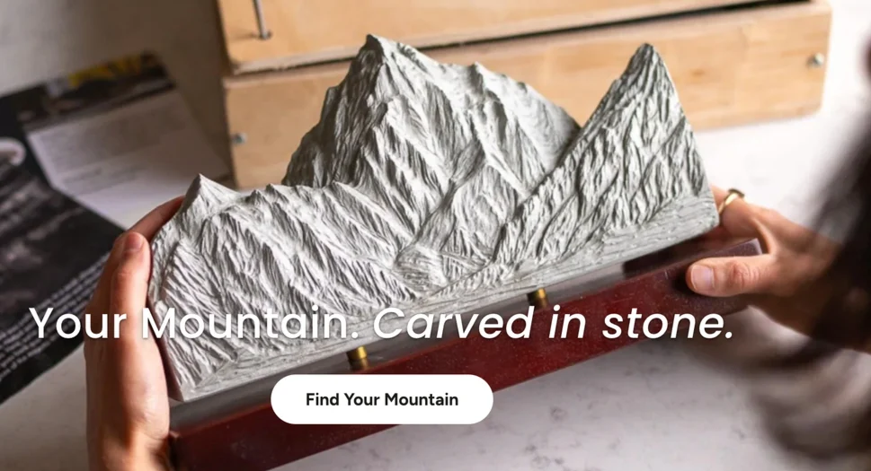 A hand-carved stone mountain sculpture held in two hands